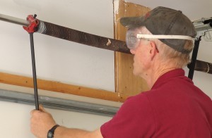 Rest winding bar against top of garage door.