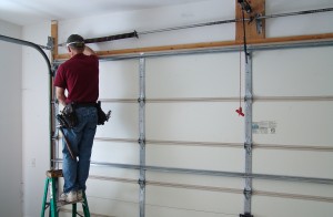 Pull garage door shaft out of end bearing plate.