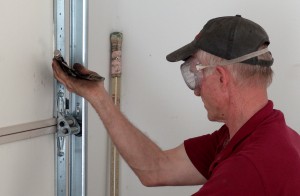 Restrain garage door from flying open.